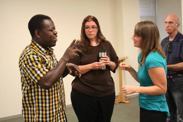 Three people in a triangle, Paul is on left using ASL while others watch