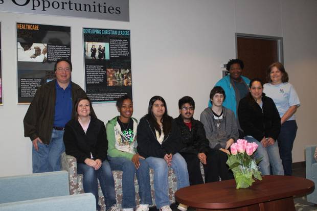 A class with several people siting on sofas